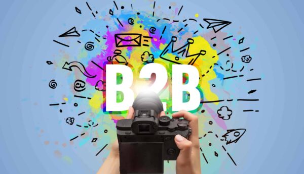 Kamera mit Schriftzug B2B auf buntem Hintergrund mit Icons